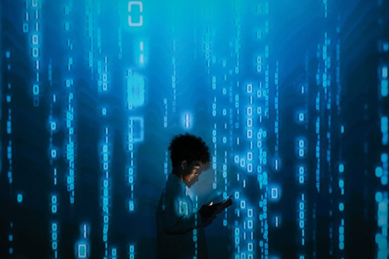 Silhouette of a person using a smartphone surrounded by digital binary code projections. — Pro Tips That You Should Know Befo