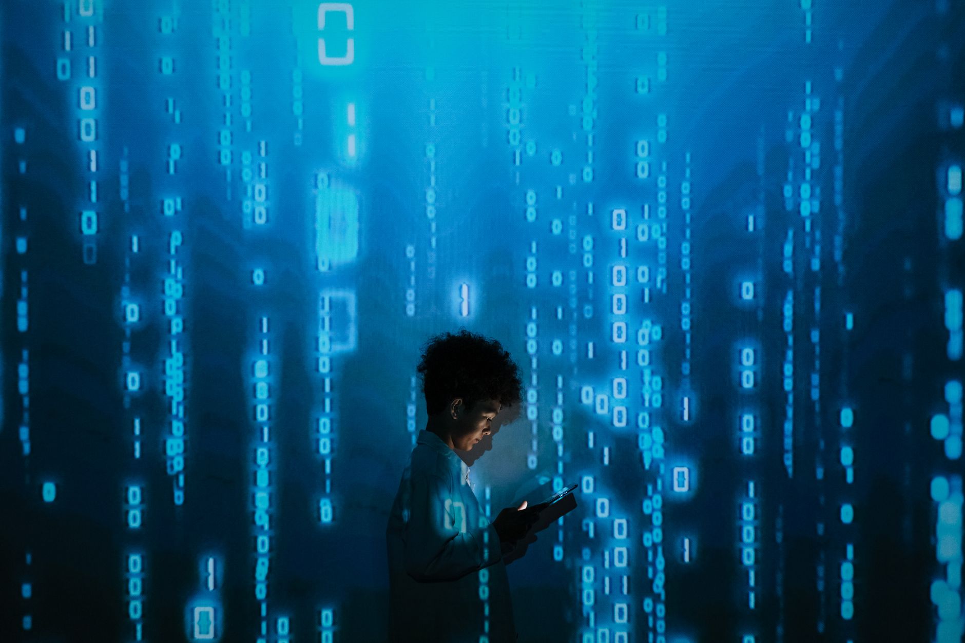 Silhouette of a person using a smartphone surrounded by digital binary code projections. — Pro Tips That You Should Know Befo