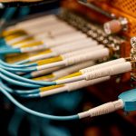 From above of optical switch equipment with many similar connectors with rubber cables and metal parts — Read this to know if
