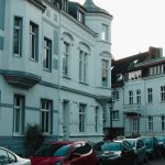 Scenic view of a historical European street with vintage buildings and parked cars. — Seven Ways To Get The Cheapest Car Insu