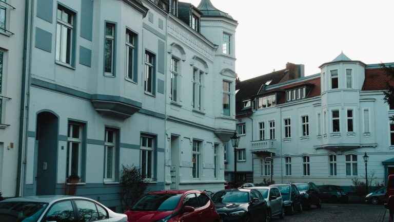 Scenic view of a historical European street with vintage buildings and parked cars. — Seven Ways To Get The Cheapest Car Insu