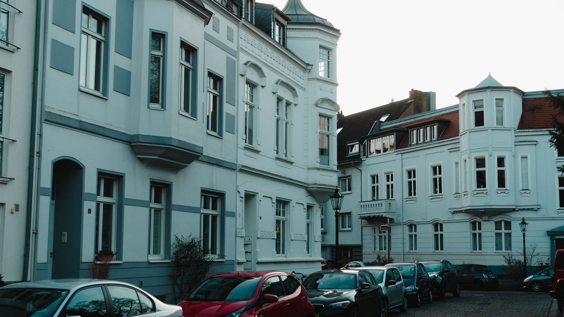 Scenic view of a historical European street with vintage buildings and parked cars. — Seven Ways To Get The Cheapest Car Insu