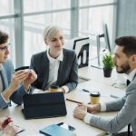 Group of professionals having a discussion in a modern office setting with natural light. — Spacious Beachfront Home Under $2