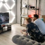 Two young men gaming together in a stylish modern living room with a large TV. — Aim for The Jackpot With Slot PG