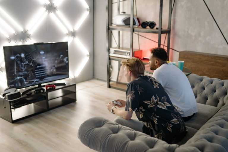 Two young men gaming together in a stylish modern living room with a large TV. — Aim for The Jackpot With Slot PG