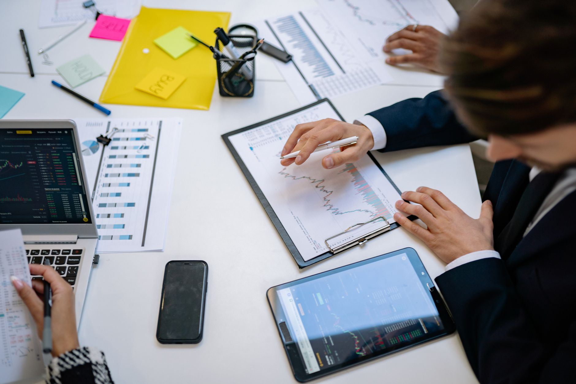 Team reviewing financial charts and digital data on tablets in an office setting. — The Exciting Reasons Why You Shou