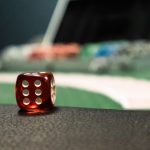 A close-up of a red dice on a casino table, evoking a sense of gambling excitement. — The Best Online Gambling Sites for Begi