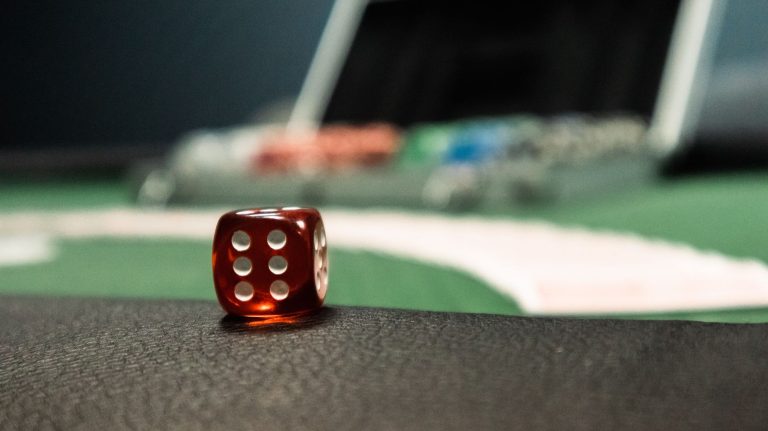 A close-up of a red dice on a casino table, evoking a sense of gambling excitement. — The Best Online Gambling Sites for Begi