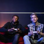 Two young men enjoying video games together on a couch, capturing leisure and friendship. — The Rise of Online Casino Gaming