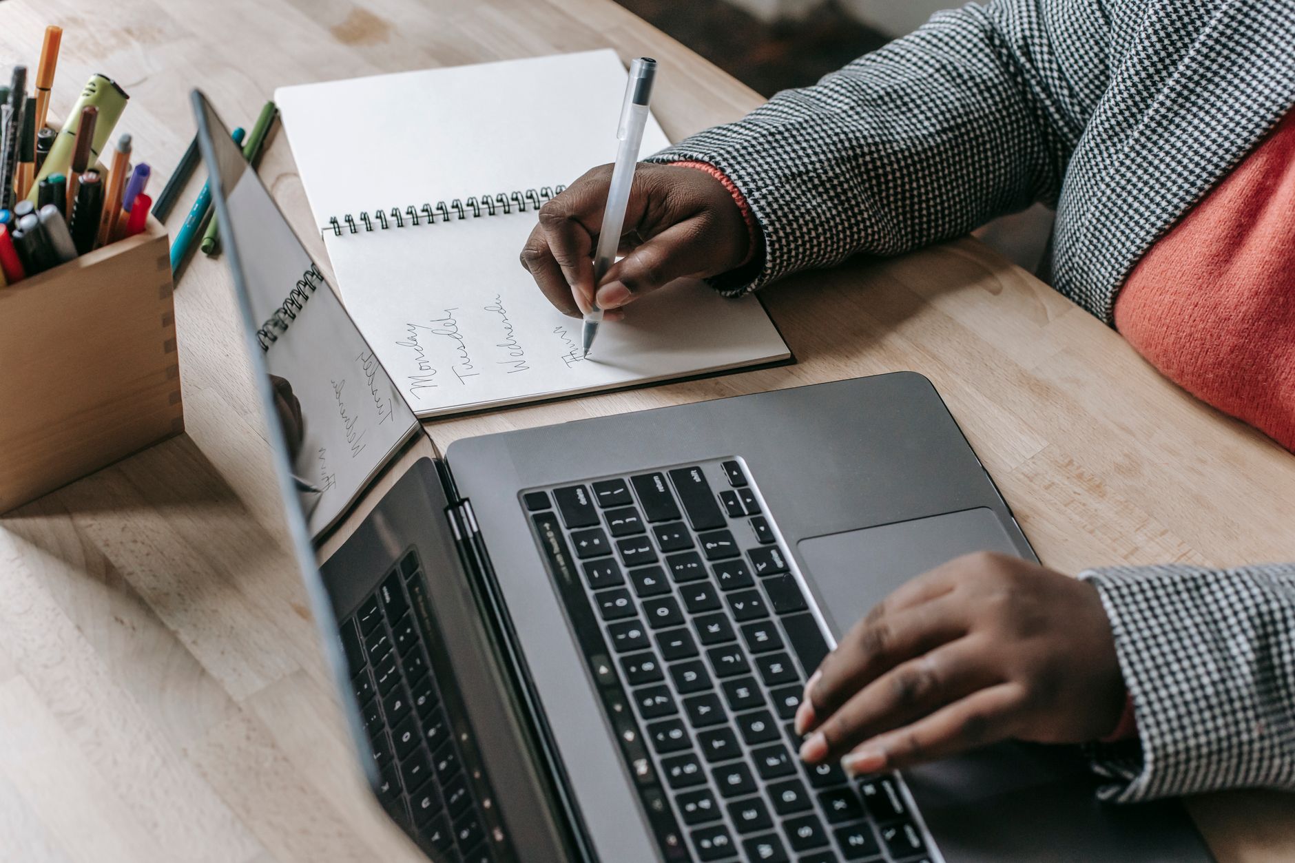 Crop unrecognizable African American female in formal wear writing notes in notepad while working on laptop — Tips for Findin