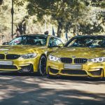 Two luxury BMW cars parked under trees in New Delhi on a sunny day. — Tips to Appoint An Auto Locksmith for Reprogramming the