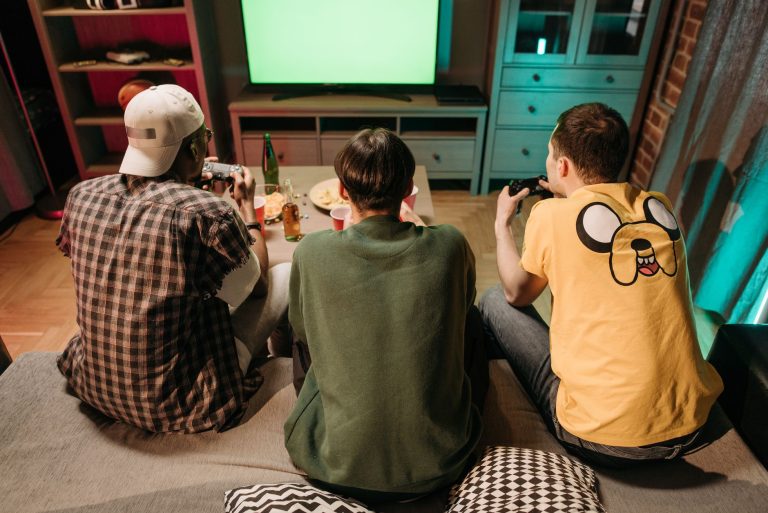 Three young men enjoying a home gaming session together, playing video games in a cozy indoors setting. — Try Your Luck and W