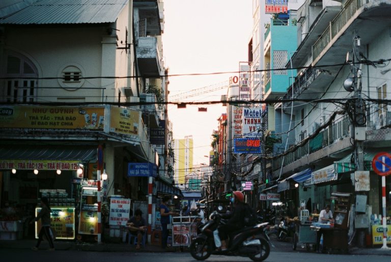 Colorful busy street scene in Cần Thơ, Vietnam with vibrant signs and people. — Types of basic security guards training