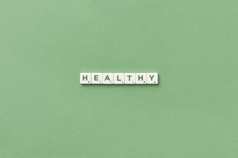 Scrabble tiles spelling the word 'healthy' on a light green background, top view. — Types of Intermittent Fasting