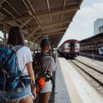 Two backpackers waiting at a railway station, ready for their travel adventure. — Ultimate Dubai desert safari tour Highlight
