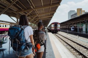 Two backpackers waiting at a railway station, ready for their travel adventure. — Ultimate Dubai desert safari tour Highlight