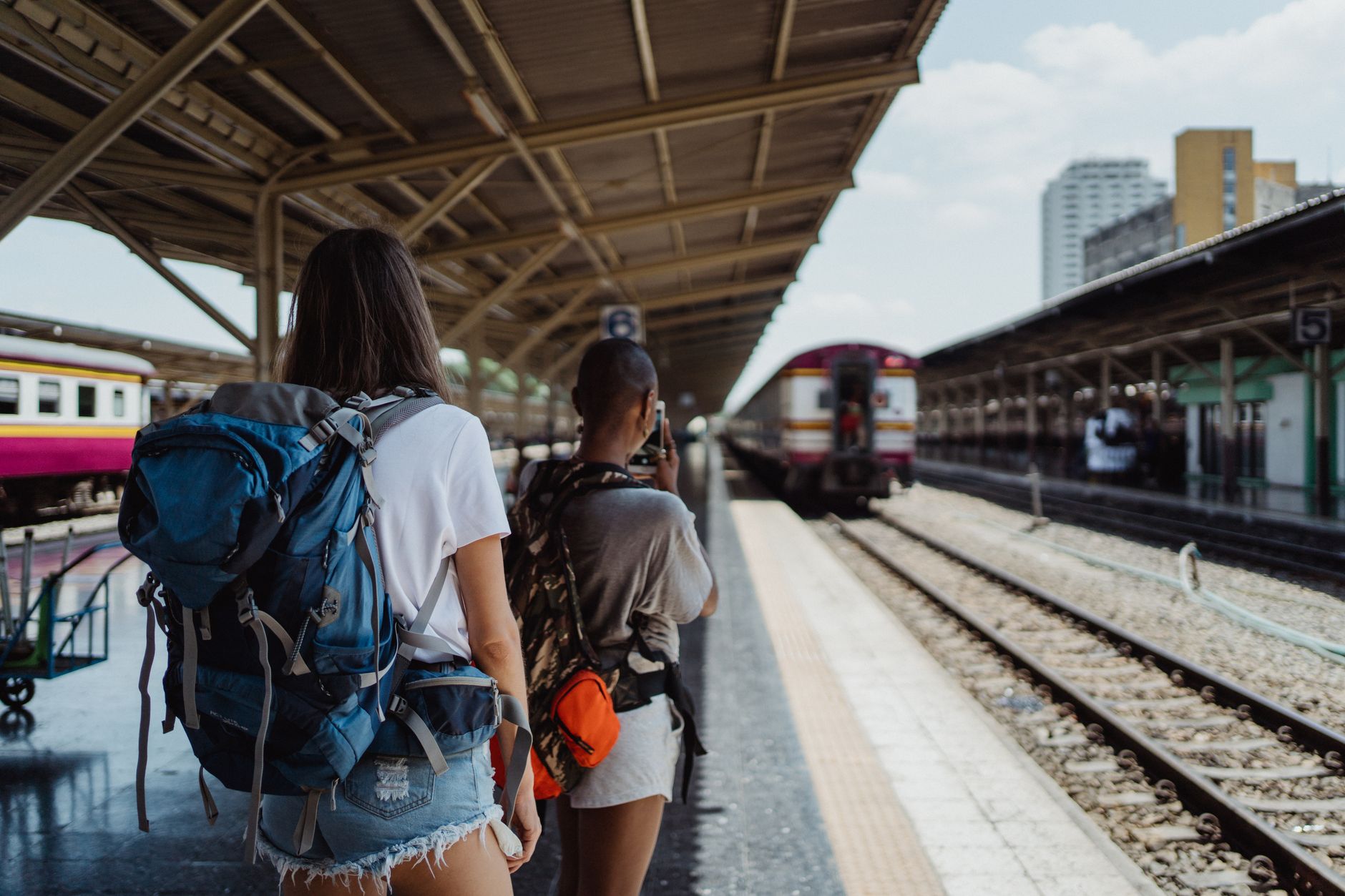 Two backpackers waiting at a railway station, ready for their travel adventure. — Ultimate Dubai desert safari tour Highlight