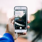Close-up of a hand holding a smartphone while capturing a cityscape outdoors. — What Is A Super Server And How Do They Proces