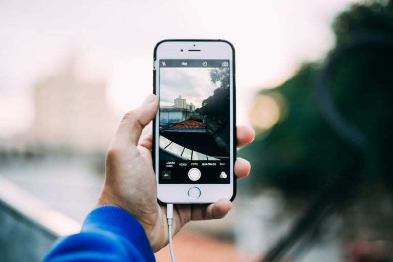Close-up of a hand holding a smartphone while capturing a cityscape outdoors. — What Is A Super Server And How Do They Proces
