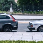 A close-up view of two cars parked on a city street near a green park on a sunny day. — What will the electronic sun visor fo