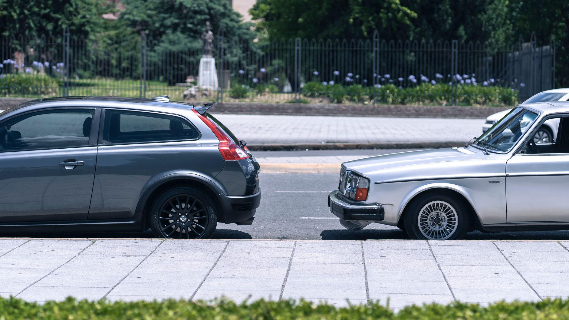 A close-up view of two cars parked on a city street near a green park on a sunny day. — What will the electronic sun visor fo