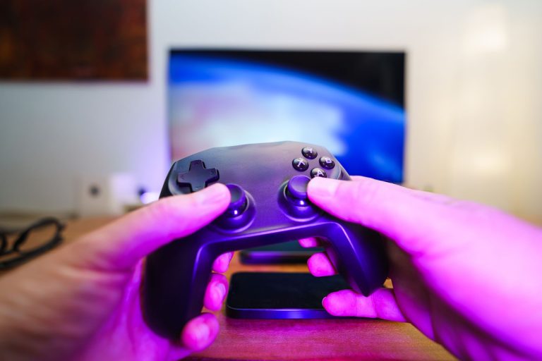 Close-up of hands holding a game controller in front of a TV screen. Perfect for entertainment setups. — Why does the person