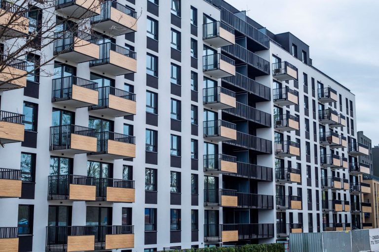 Contemporary apartment building with balconies in urban setting, showcasing modern architecture. — Why renting a Cost Effect