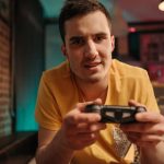 Focused young man enjoying video games with a controller indoors. — Why The Casimba Online casino Canada Is One OfThe MostPop
