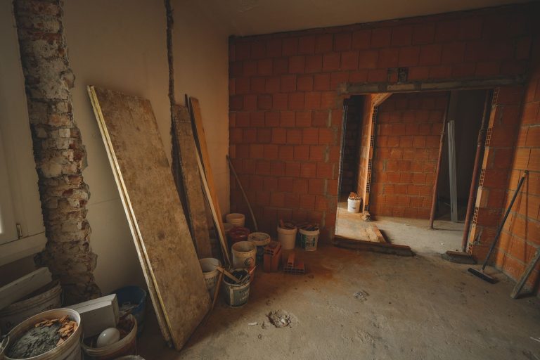 A red brick wall under construction with tools and materials scattered around in a renovation project. — WHY TIGER AND LEOPAR